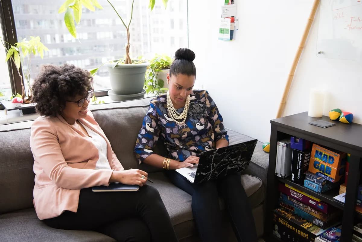 Two investors reviewing results on a laptop